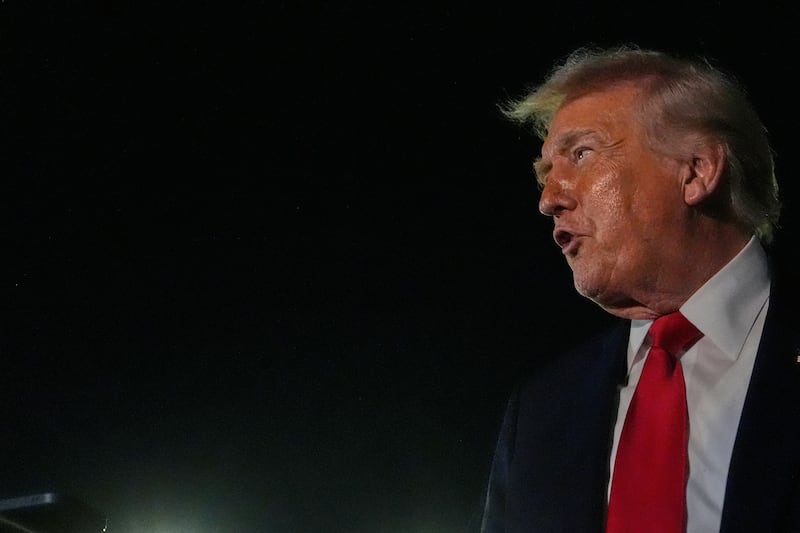 President Donald Trump speaks to reporters before boarding Air Force One at Palm Beach...