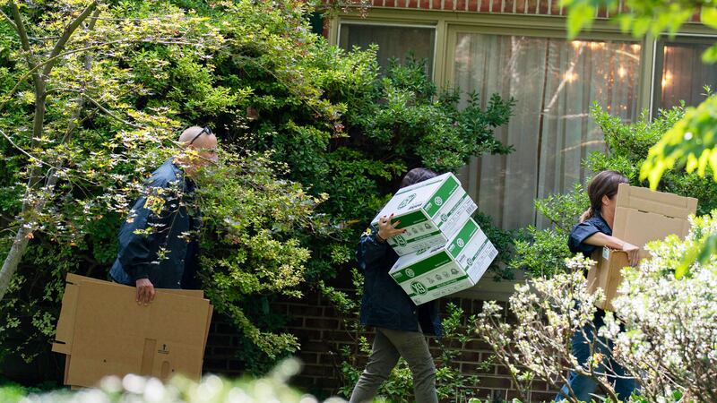 FBI agents carry empty boxes to former national security adviser John Bolton's house, Friday,...